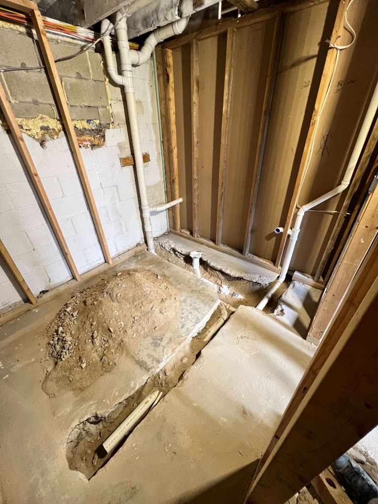 Basement bathroom excavation with PVC drain pipes