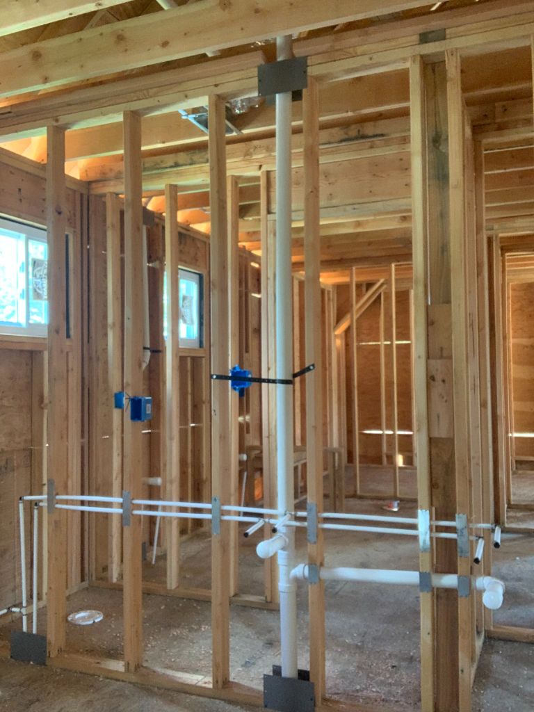 Bathroom rough-in with PVC drain and supply lines in framing