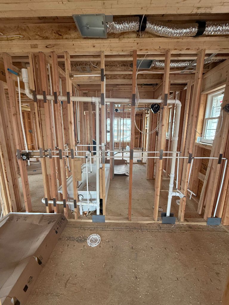 Multiple PVC pipe runs through new construction framing