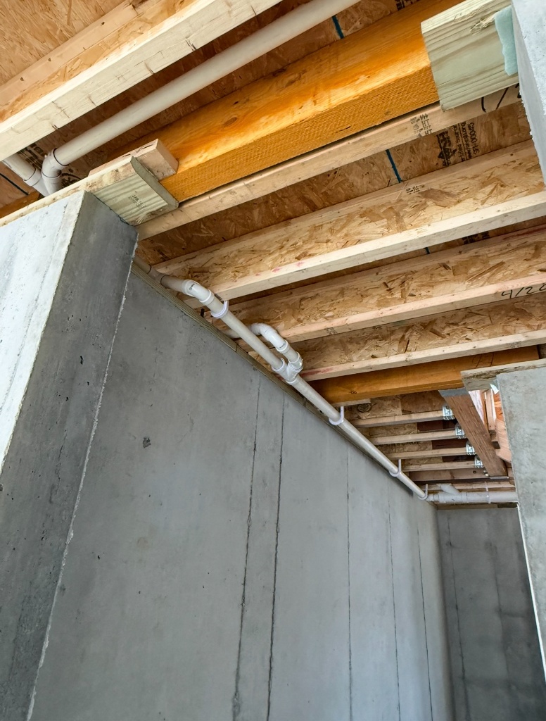 Under-floor joist PVC pipe rough-in in new construction