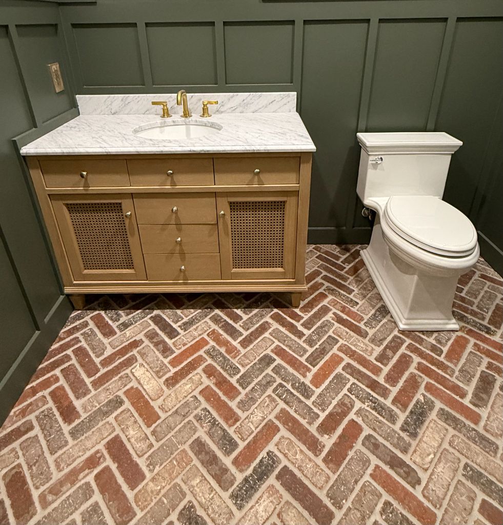 Herringbone brick floor with marble vanity and toilet