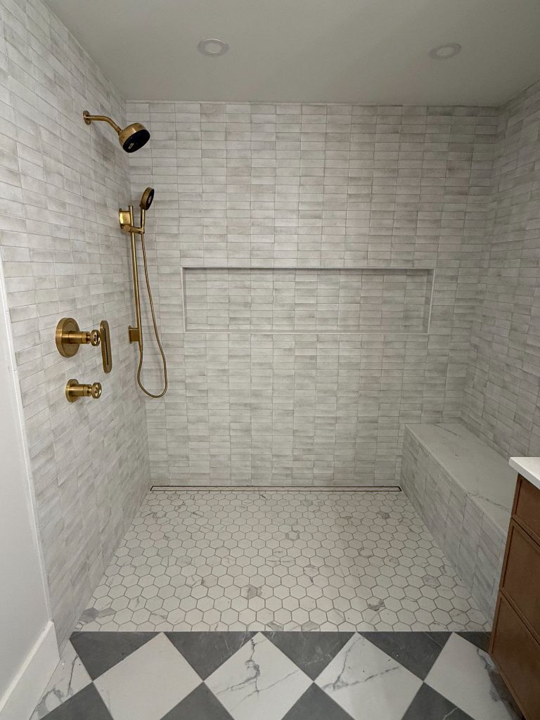 Walk-in shower with gold fixtures and built-in niche