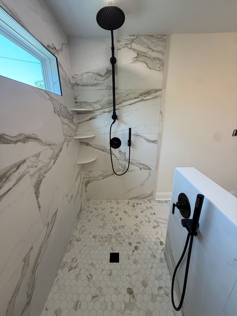 Floor-to-ceiling marble shower with black fixtures