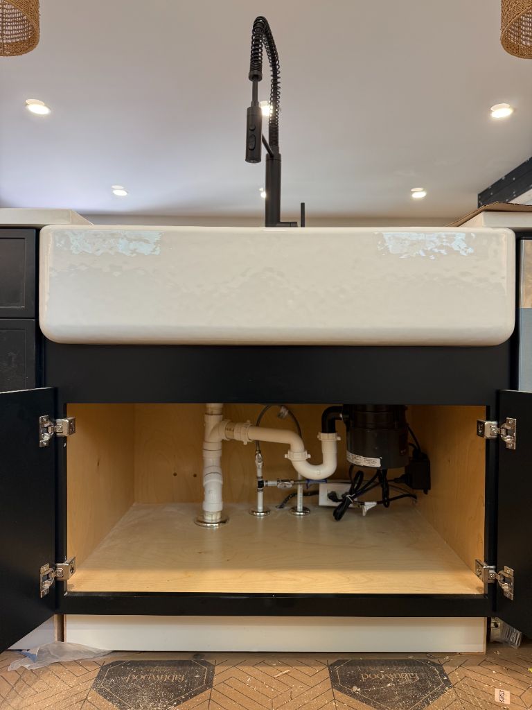 Farmhouse apron sink installed with matte black faucet