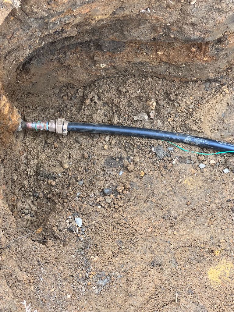 New black poly water service line connected underground